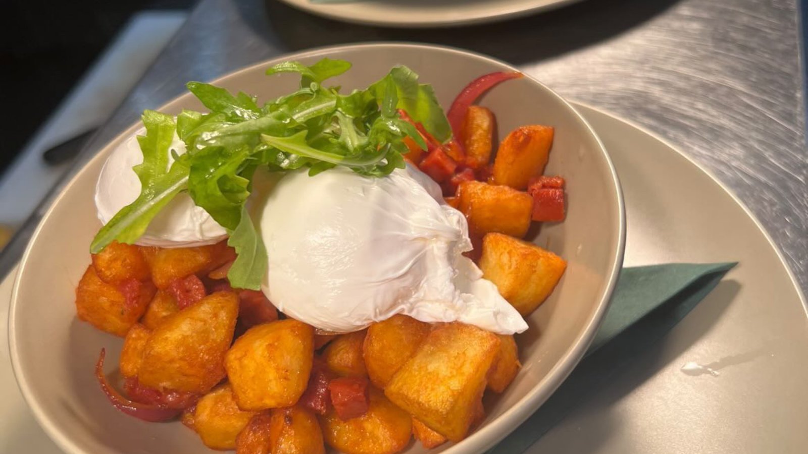 Poached eggs with golden potatoes and rocket in a bowl